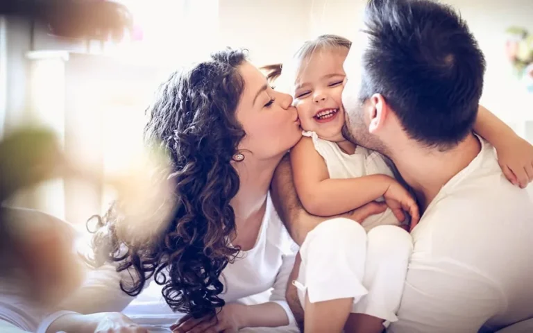 mother father kissing daughter