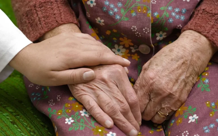 young hand with doctors coat holding old hands