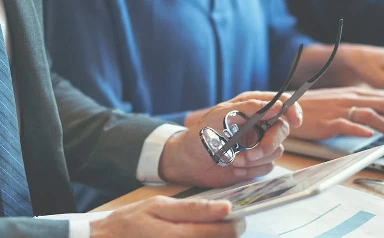 male hands holding glasses and tablet at conference table