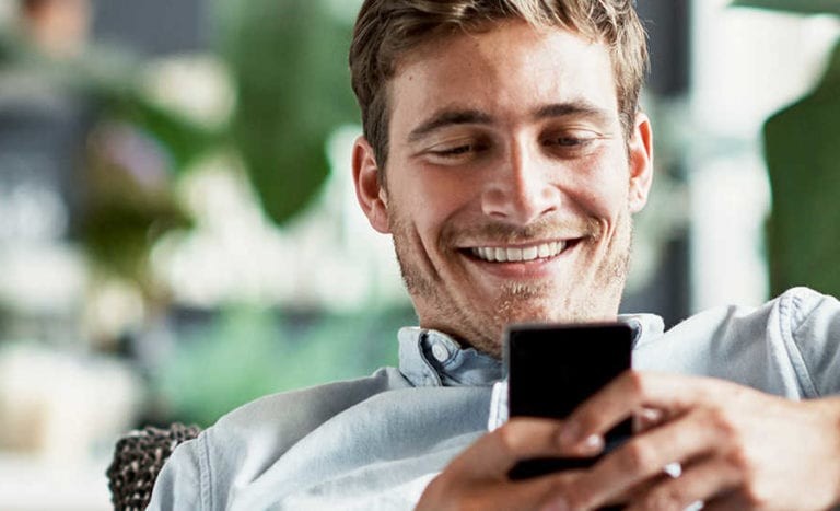 smiling man looking at phone