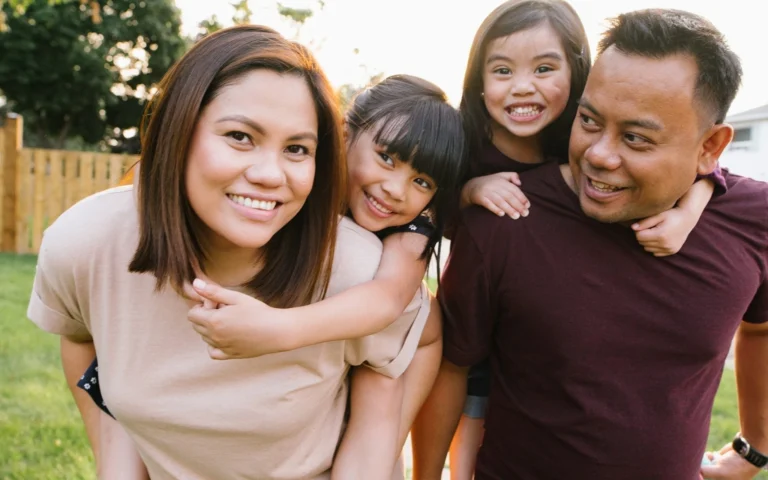 mother and father giving young children piggy back rides