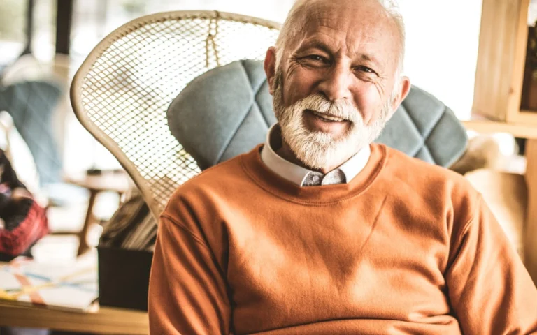 smiling older man sitting in chair