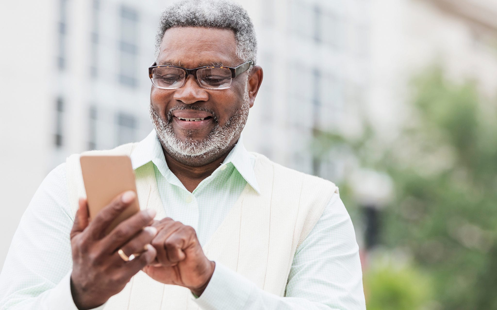 Older man reading a text from his health plan