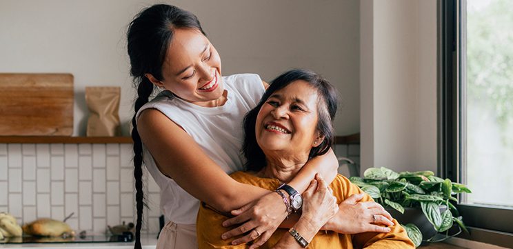 mother and adult daughter hugging and laughing