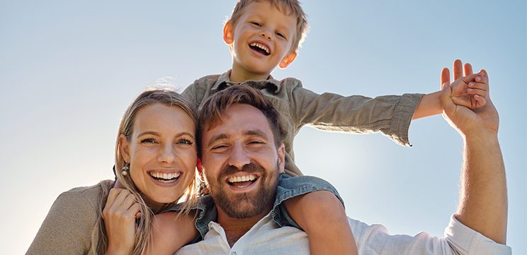 happy mum dad and son playing outside