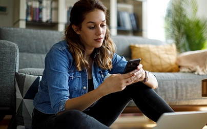 Person at home managing a behavioral health support call on phone with laptop open