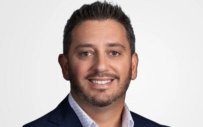 Dan Sher, Chief Product Officer at Carenet Health, smiling in business attire against a neutral background