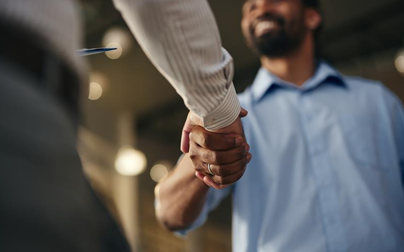 Healthcare professionals shaking hands, representing Carenet Health's Everest Group PEAK Matrix recognition