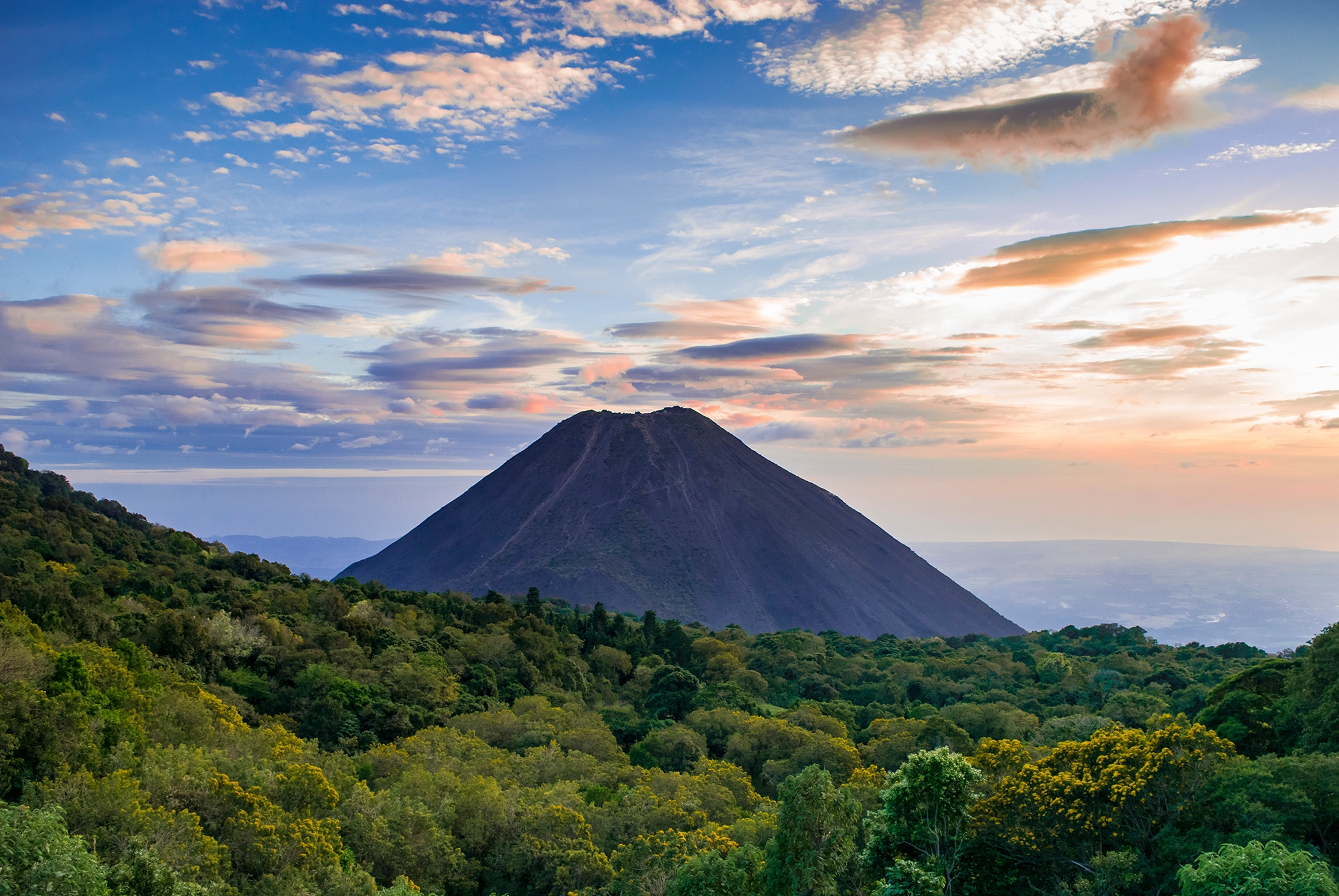 Izalco volcano rising above tropical forest at sunset, El Salvador — nearshore location for Carenet Health healthcare BPO services