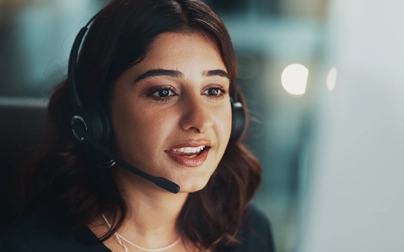 Health Advisor in a headset handling patient access scheduling calls at a contact center workstation